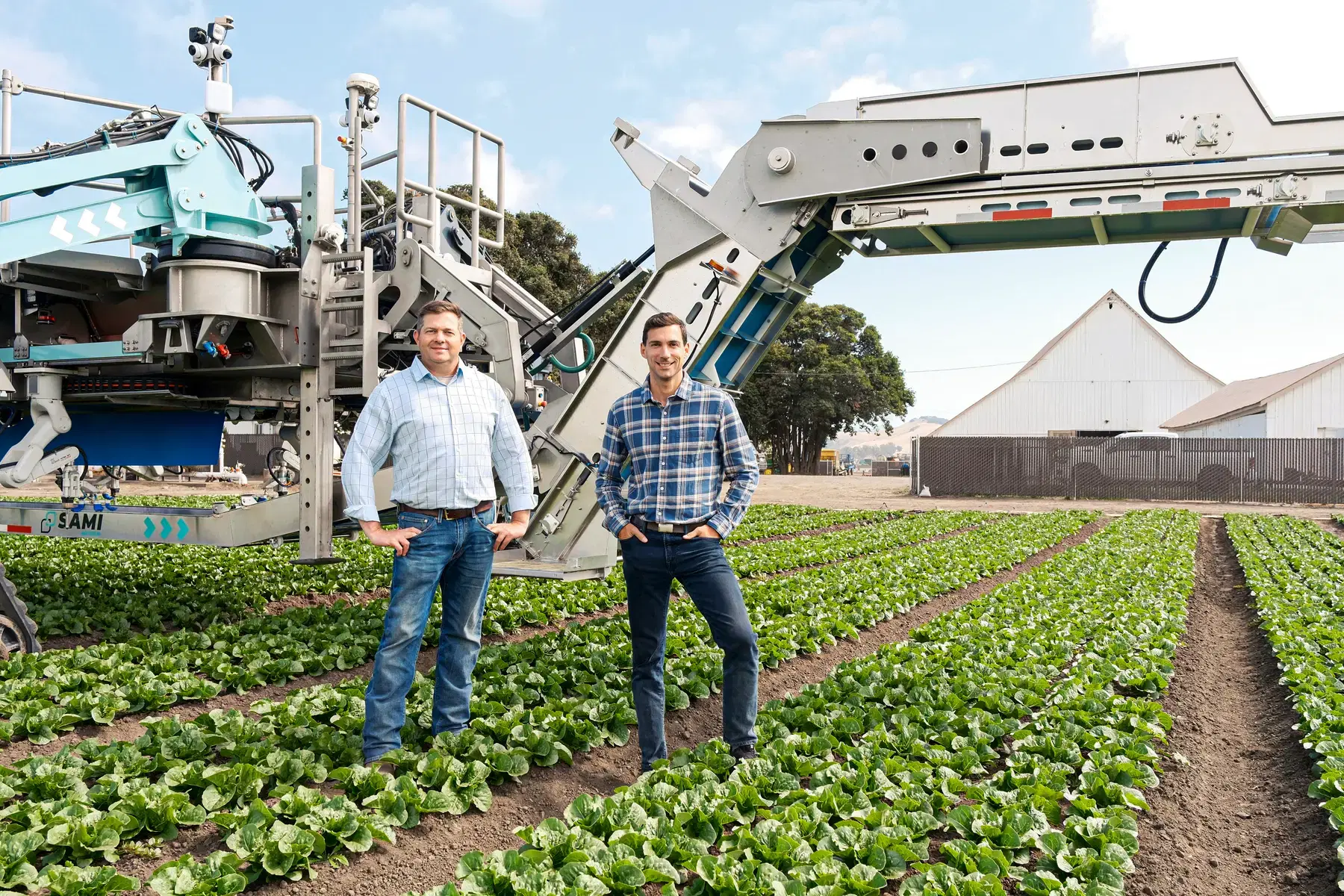 The team in front of the SAMI harvester in a romaine lettuce field in California